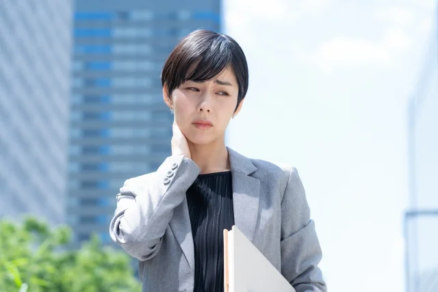 首の痛みに悩む女性