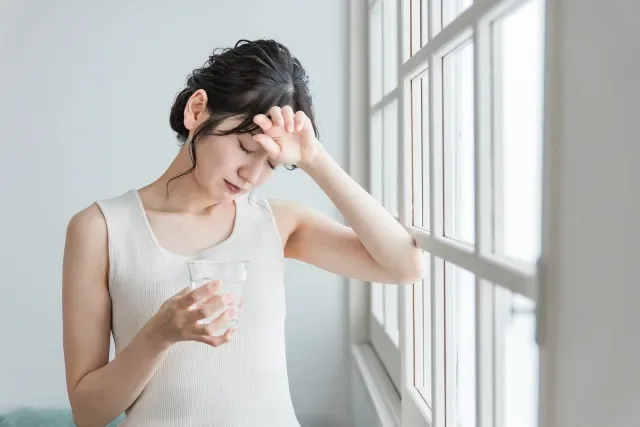 額に手を当てて疲れた様子の女性